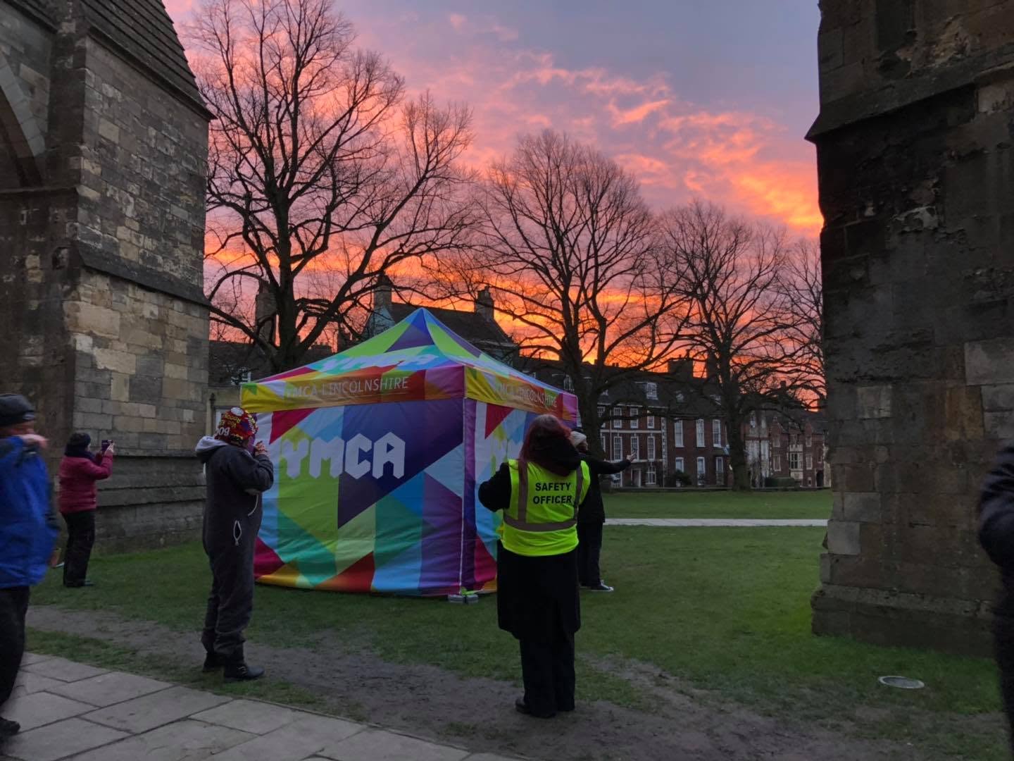 YMCA Lincolnshire branded gazebo at Lincoln Cathedral during Sleep Easy 2020 at sunset